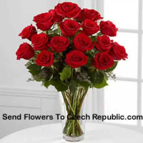 花瓶に入った19本の赤いバラとシダのアレンジメント